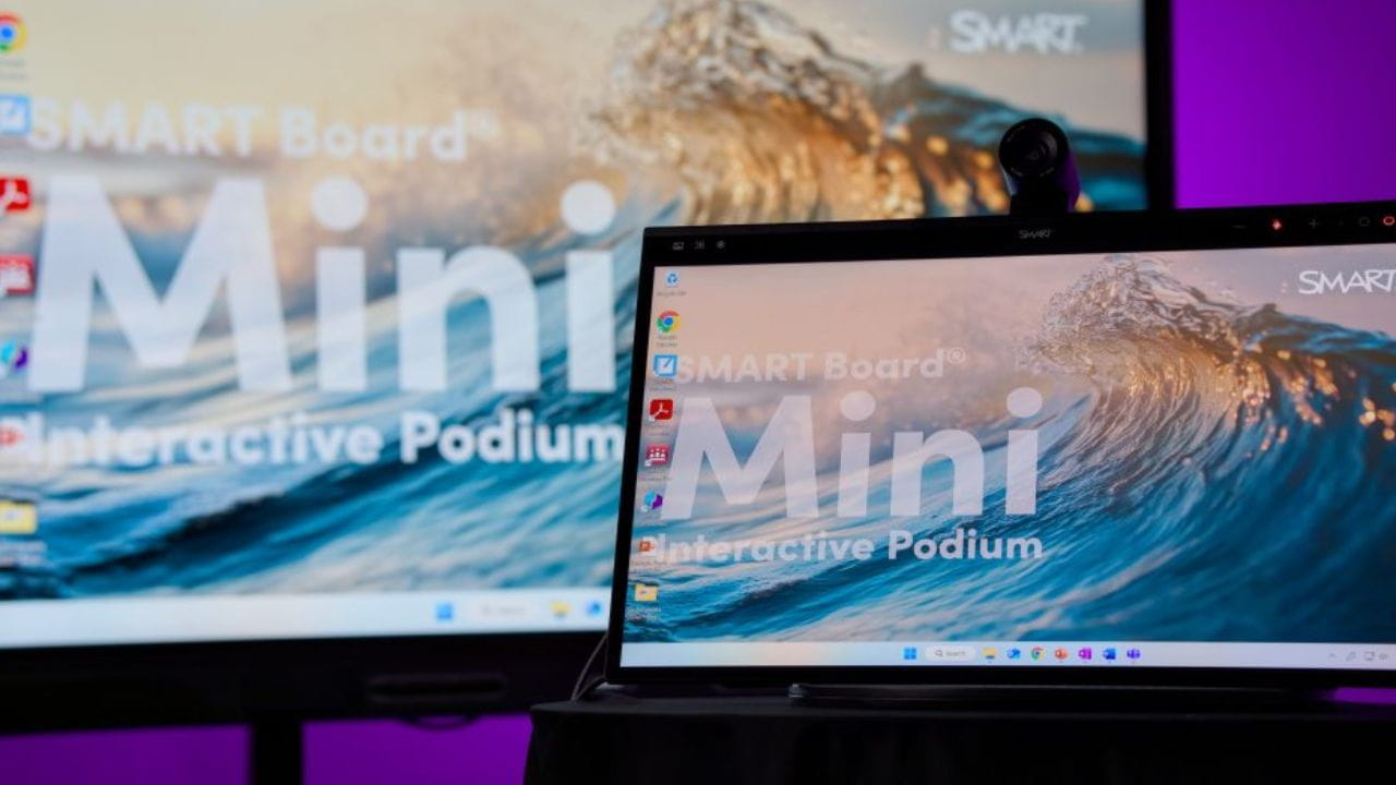 Close-up of the SMART Board Mini Interactive Podium with a secondary large interactive display in the background.
