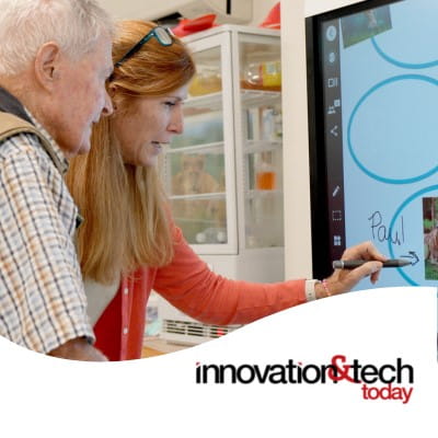 A resident at a senior home in Colorado, along with his aid, interacting with a brainstorming activity on the SMART Board. The Innovation & Tech Today logo appears in the bottom right.