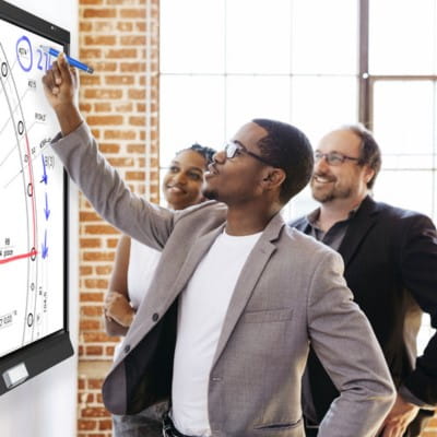 Three professionals engaging in collaborative work on a SMART interactive display.