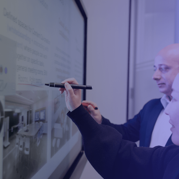 Two professionals annotating on a SMART Board for business simultaneously, provided by SMART Technologies and ATP Gov.