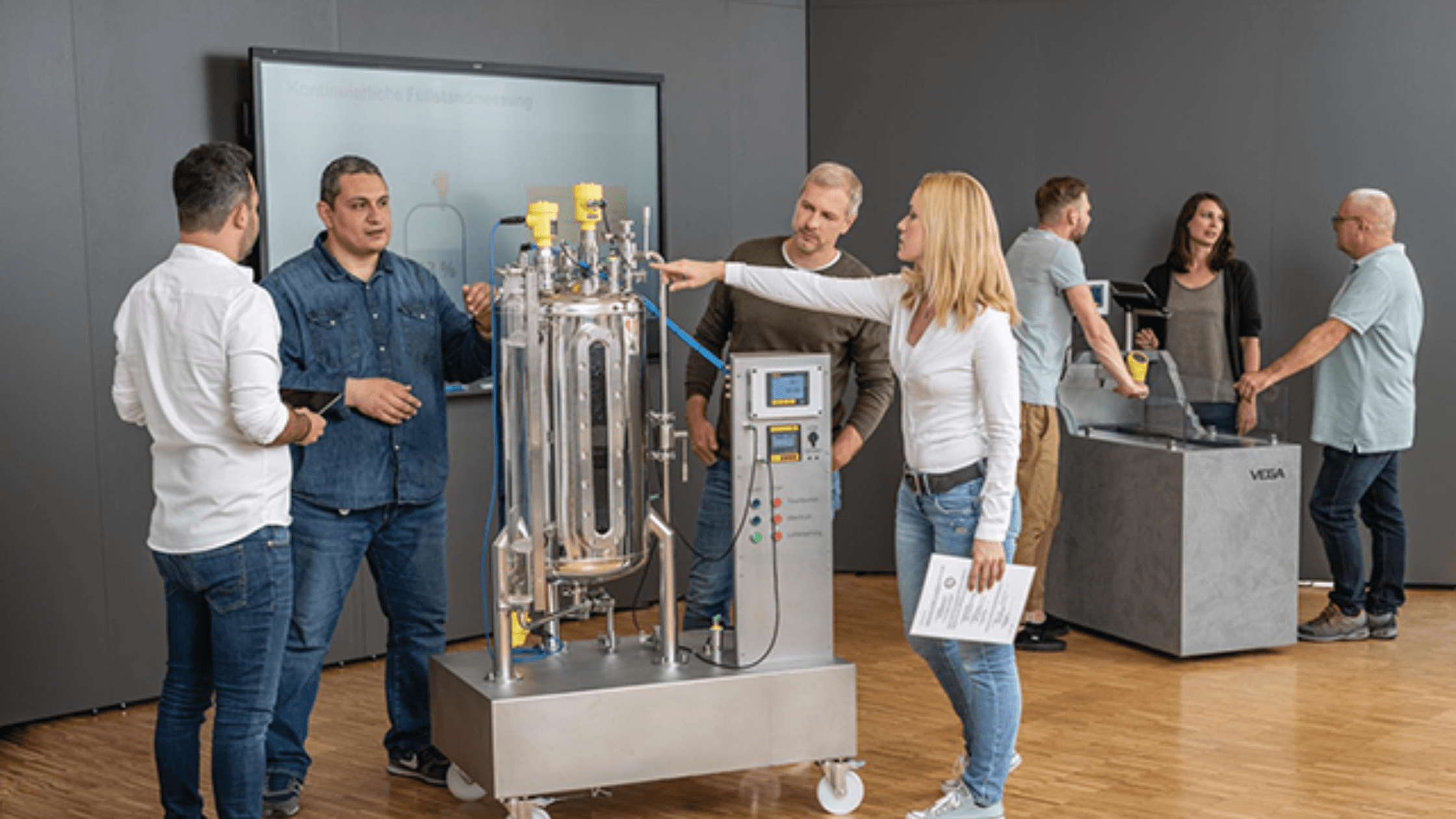VEGA employees interacting with their products in front of a SMART Board.