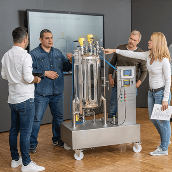 VEGA employees interacting with their products in front of a SMART Board.