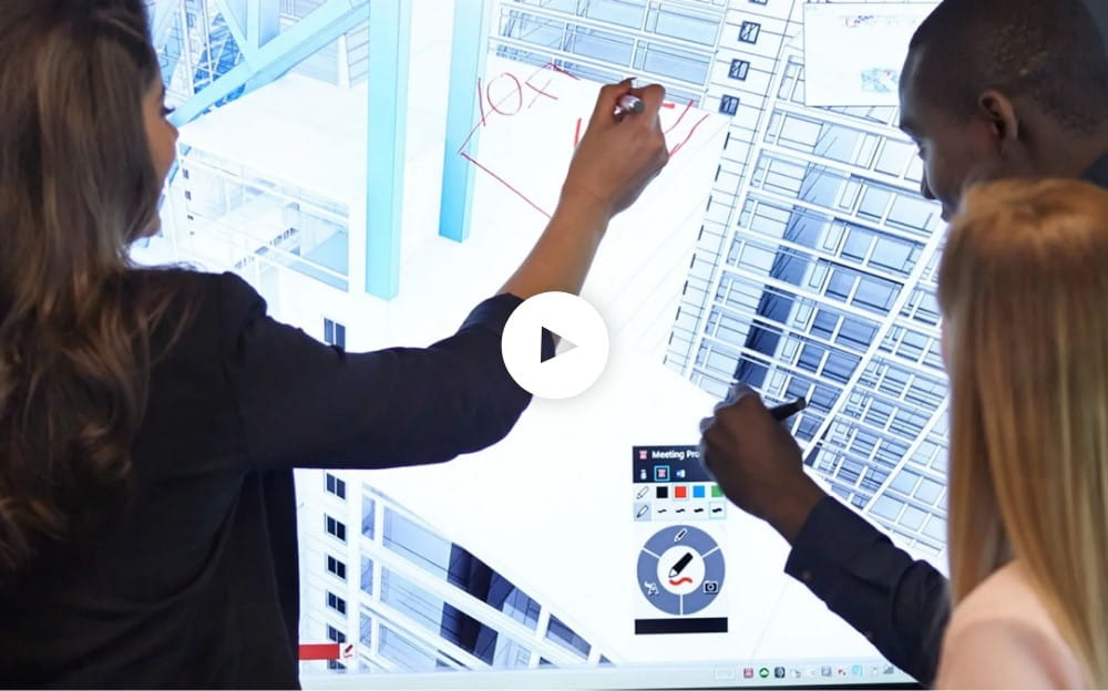 A video thumbnail showing three people, two women and a man, engaging with a large interactive SMART Board, annotating over a building design.