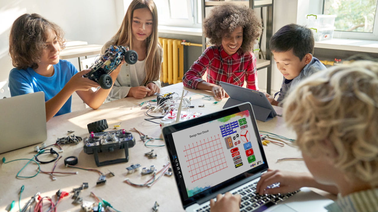 A group of students working together on a robotics project with a laptop displaying a circuit design tool.