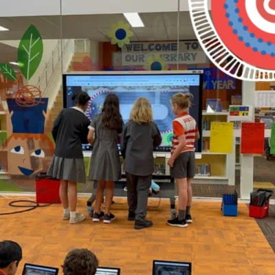 Group of South Melbourne Primary School students actively participating in an interactive session using a SMART Board in their library.