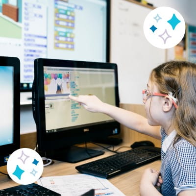 Student using SMART Notebook on a computer with a SMART Display presenting the lesson in the background.