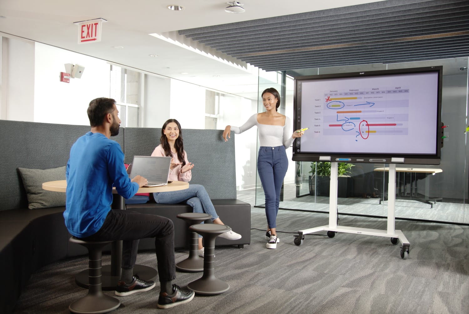 Three professionals collaborating on an interactive display for business