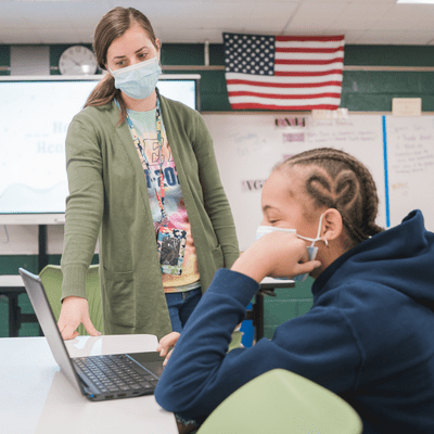 Teacher helping student on student device