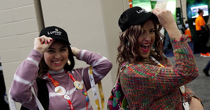 Two people showcasing Lumio merchandise with cheerful faces.
