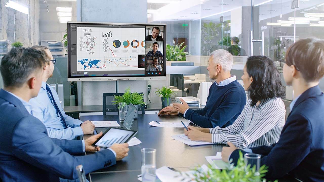Government administration team reviewing plans and financial information using SMART Meeting Pro and an interactive display.