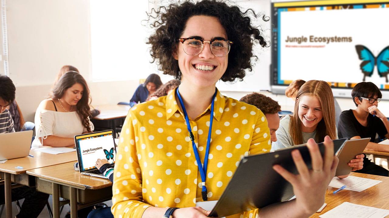 Educator guiding students through a science lesson on jungle ecosystems using Lumio and a SMART interactive display.