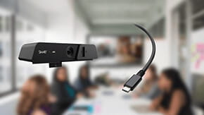 Close-up view of the SMART Ultra HD Camera 120 with a USB-C Cable 18 in focus, in a blurred meeting room environment.