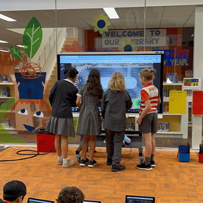 A group of students working collaboratively on an interactive display.