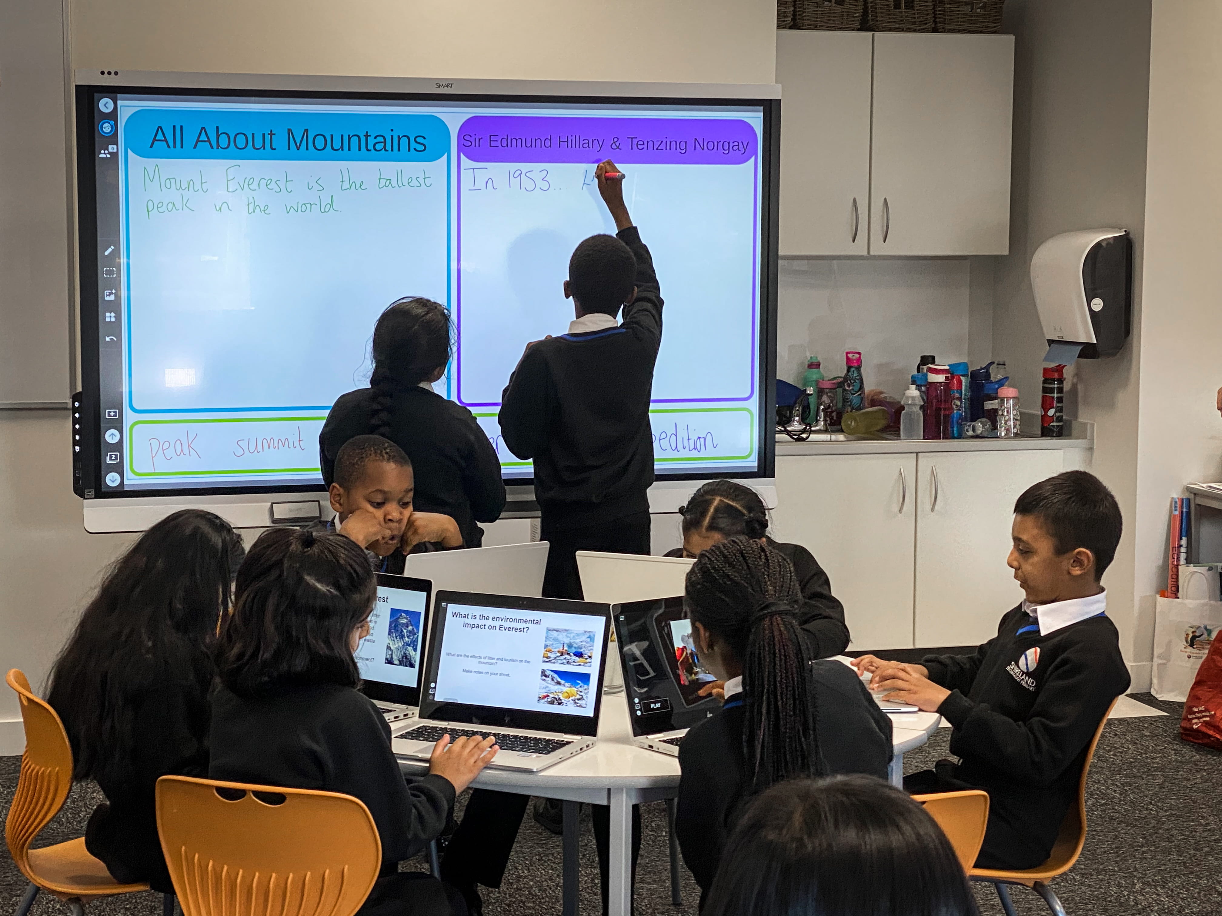 Students prepare for testing using their students devices, a classroom SMART board, and Lumio learning software. 