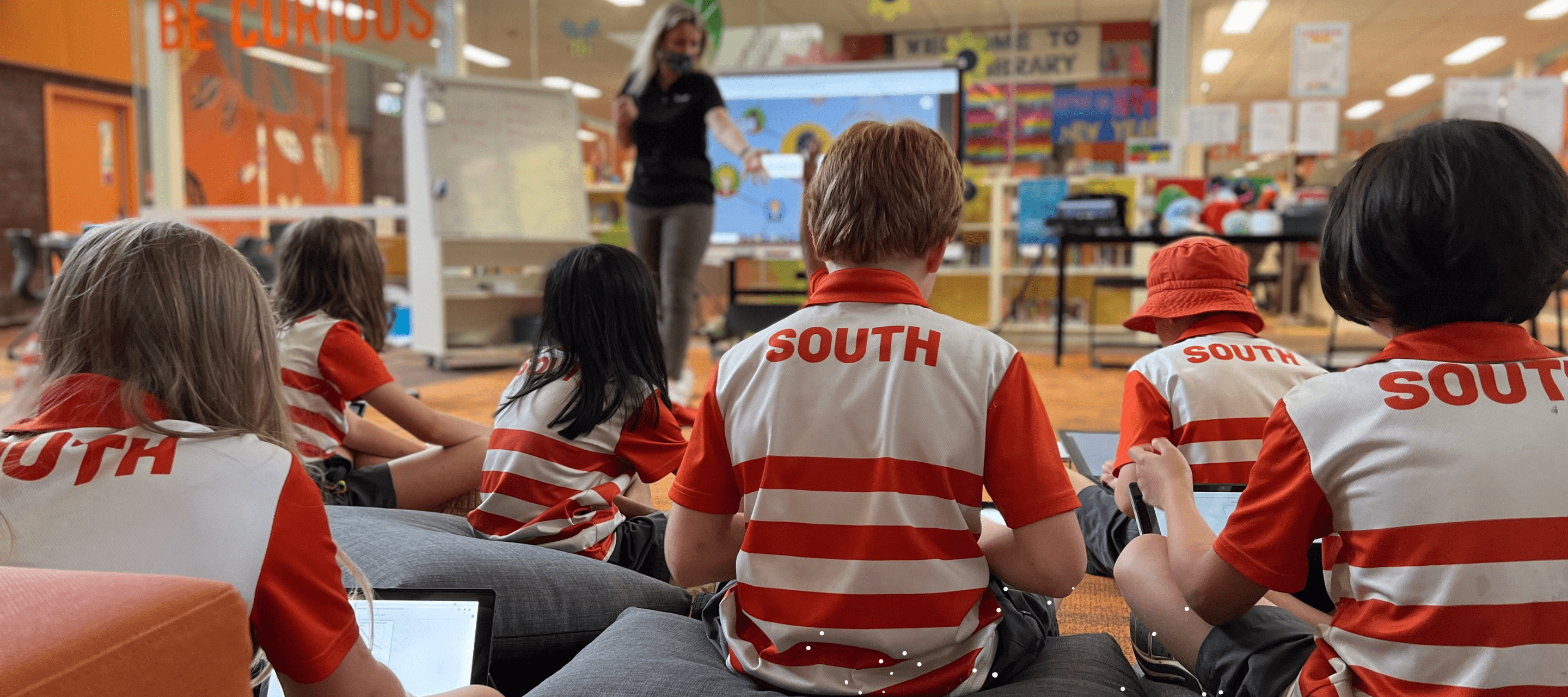 Students at South Melbourne Primary school on the ground listening to the teacher.