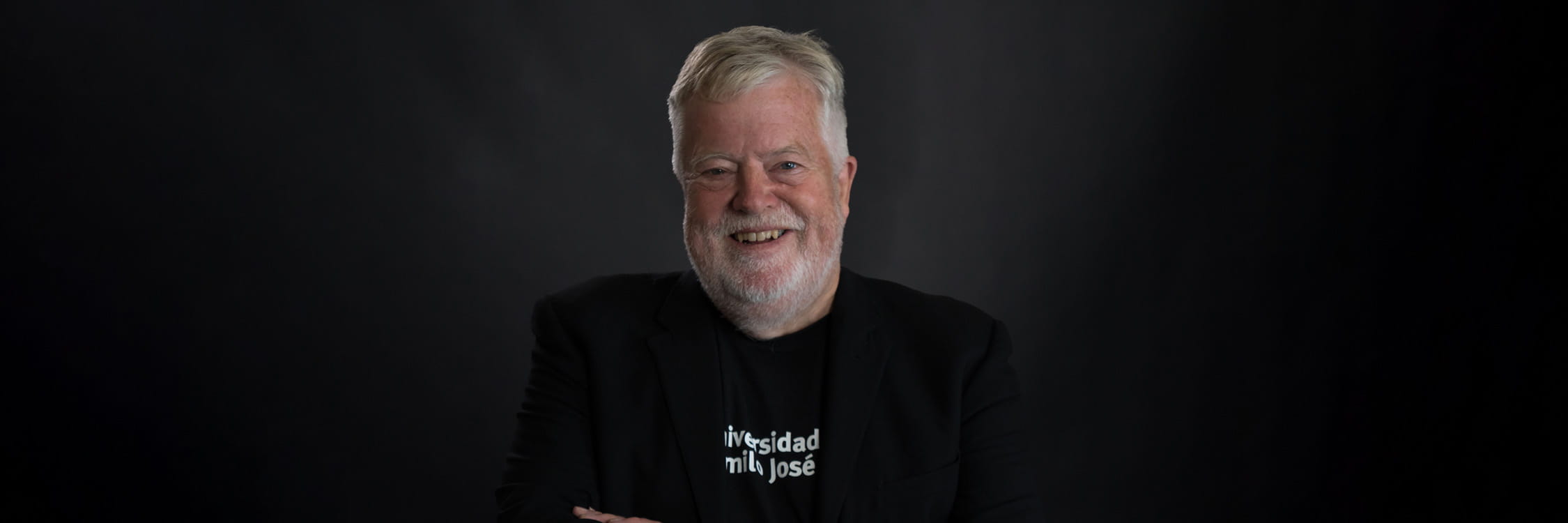 Stephen Heppell in front of a black background.