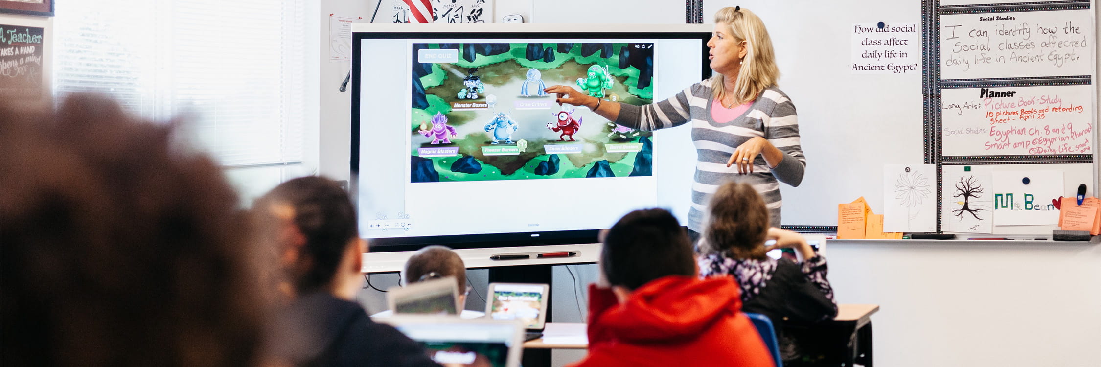 A teacher presenting to a room full of students about SMART Monster Quiz.