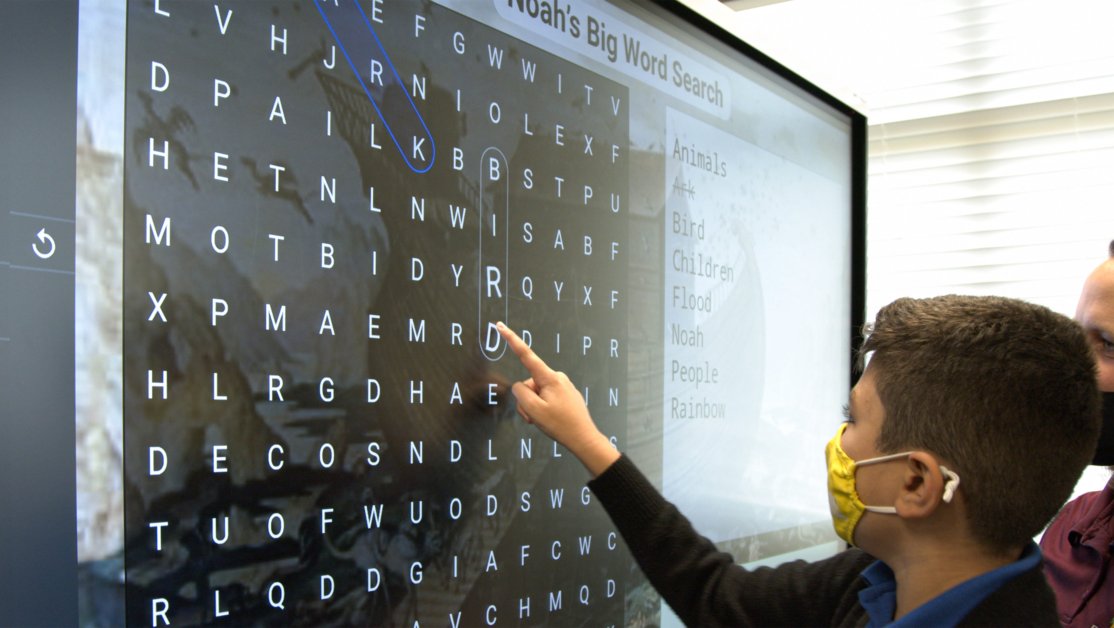 A teacher facilitates an active learning lesson in front of her SMART display.
