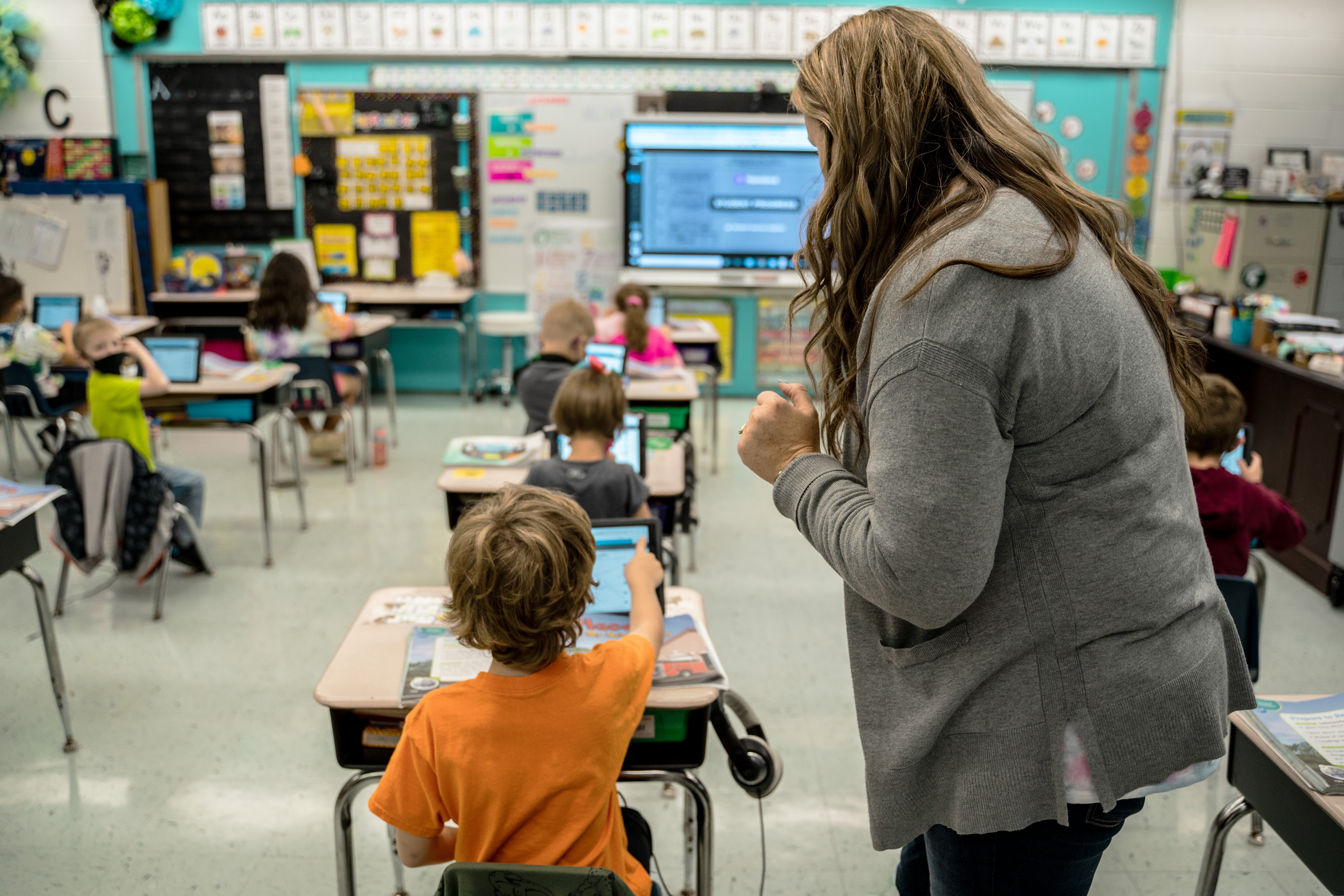 A high school students engages with the SMART display on a science lesson.