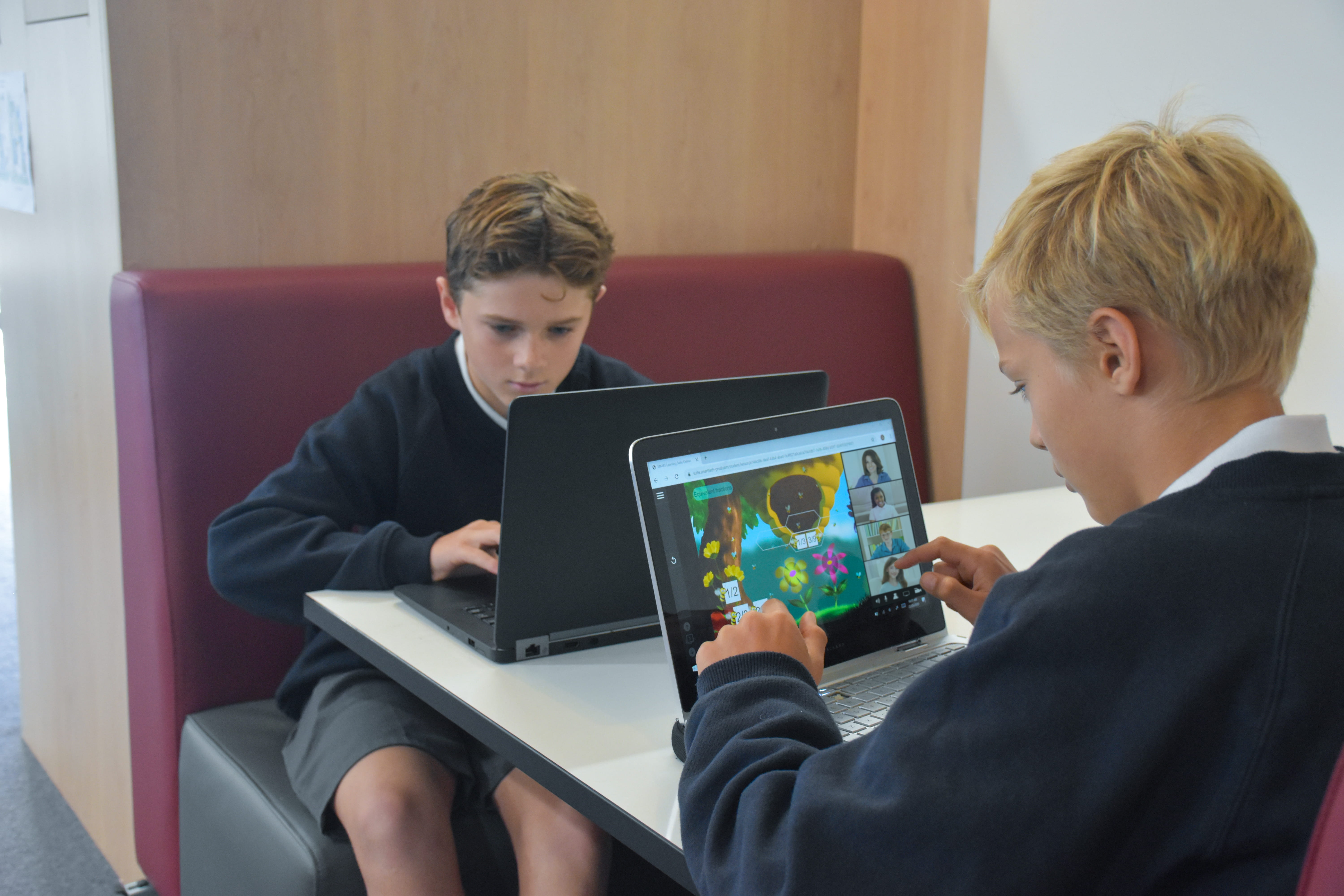 Two Australian male students complete a game-based activity on their student devices.