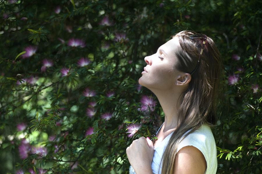 Young woman breathing fresh air in nature