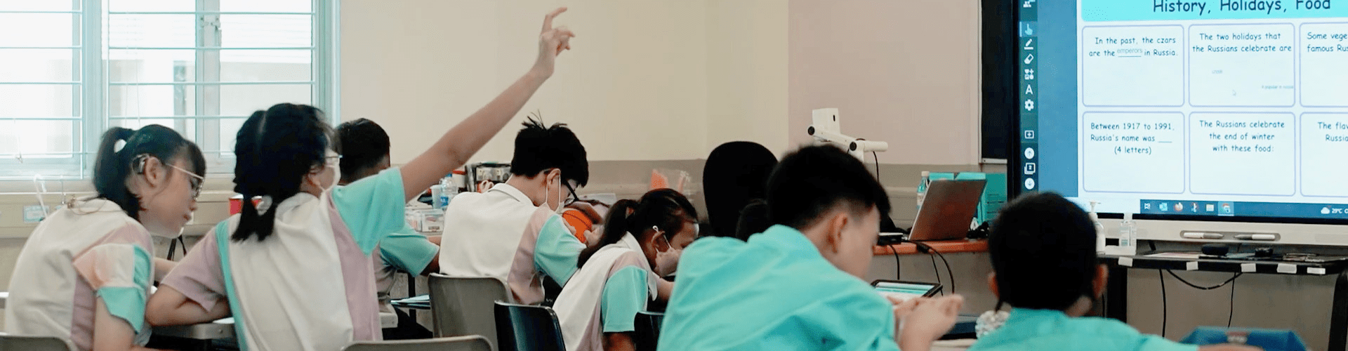 A classroom full of students working collaboratively in small breakout groups.