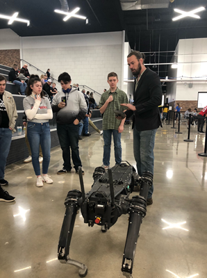 students gathering around robot at the AmTech Career Academy in Texas