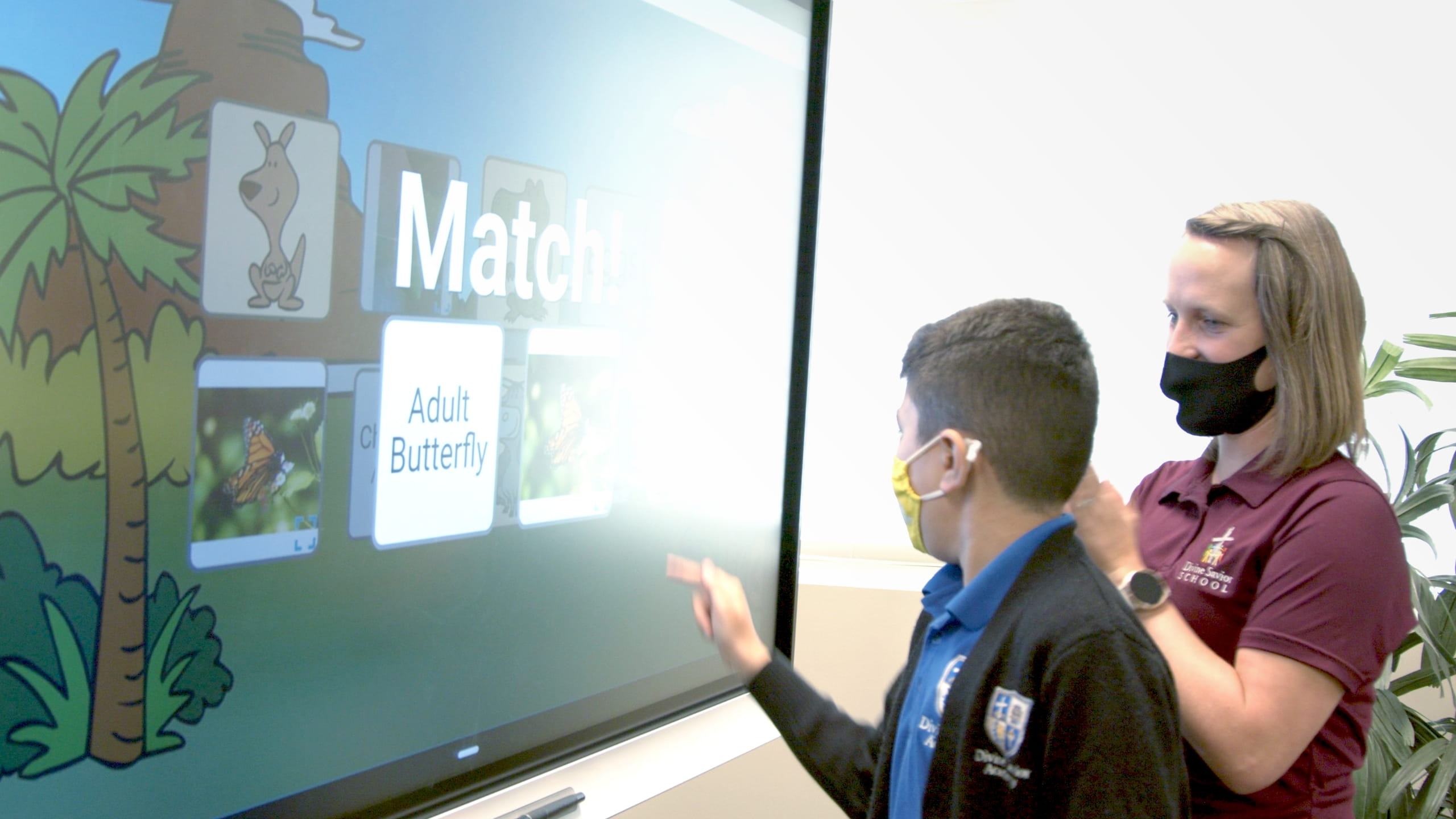 Student with teacher at a SMART board