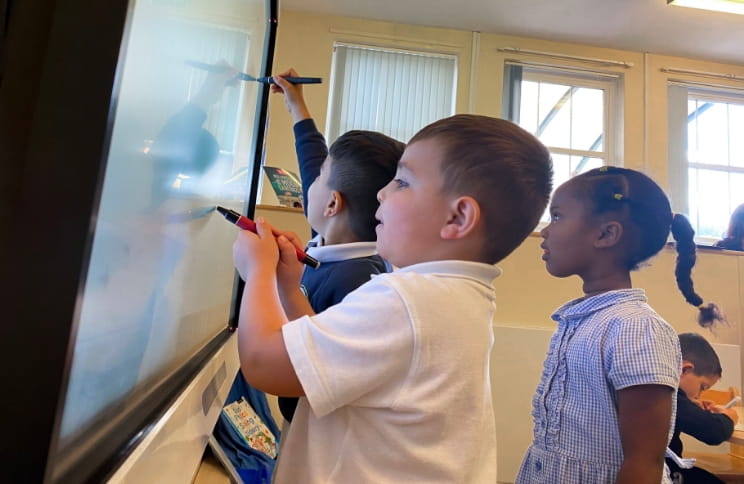 Students working on a SMART board