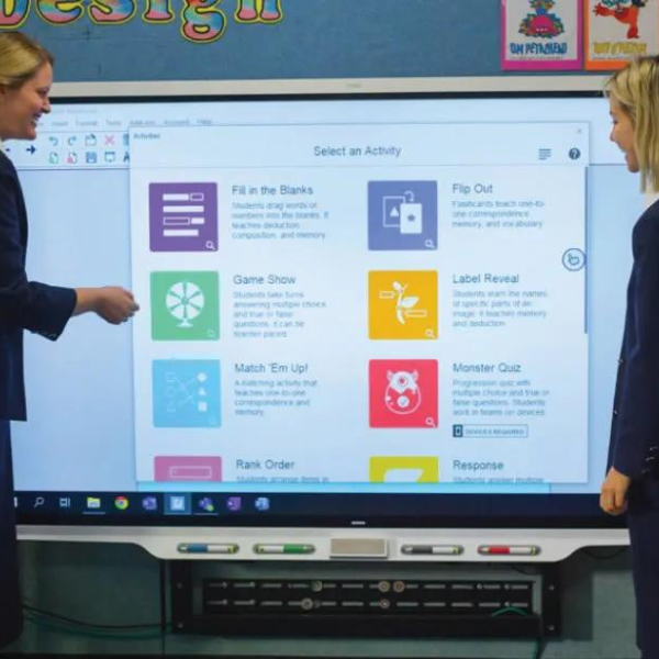 Two educators exploring ready-made activities on a SMART Board for education. 