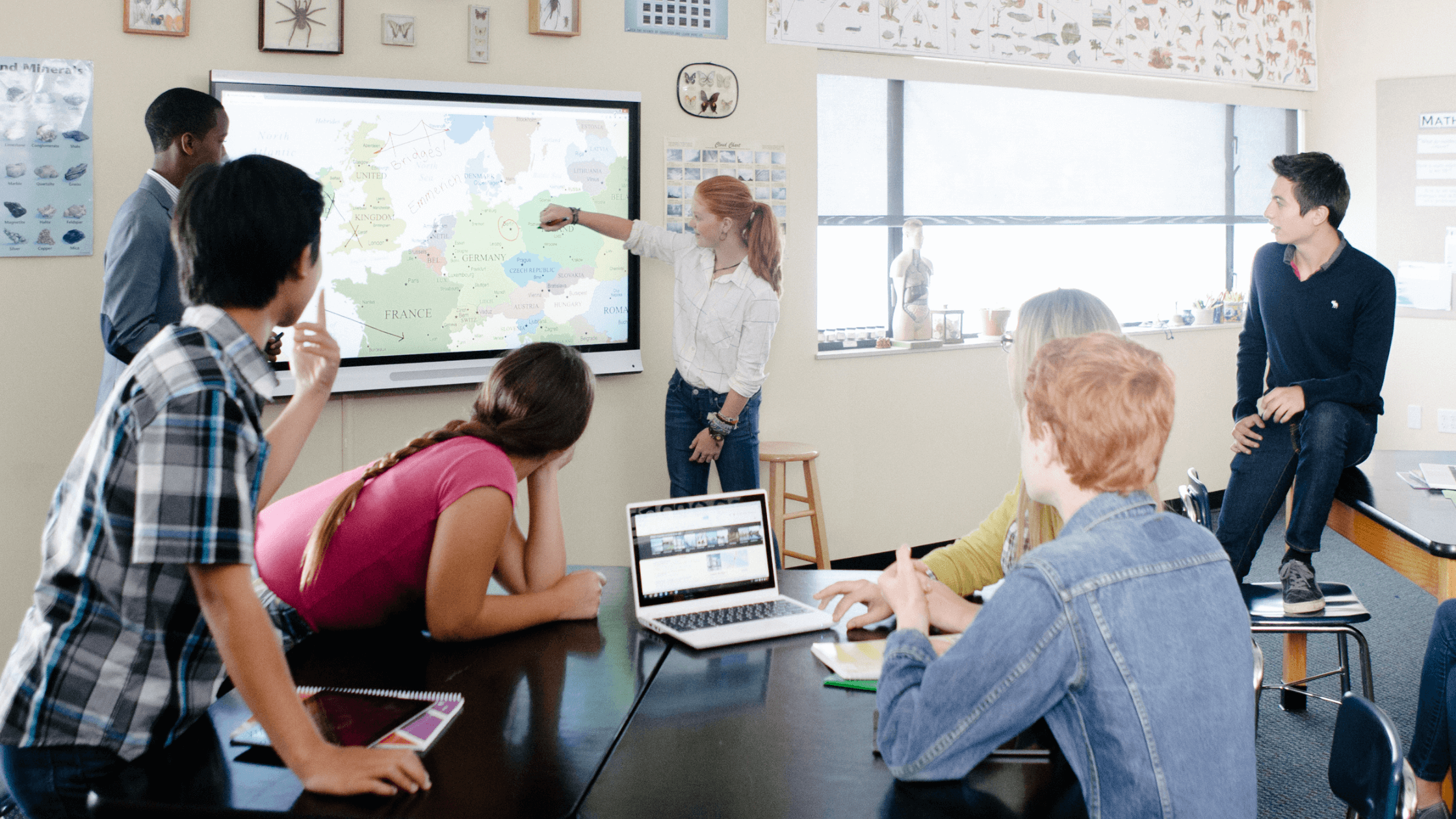 Students gathering around a SMART Board working collaboratively.