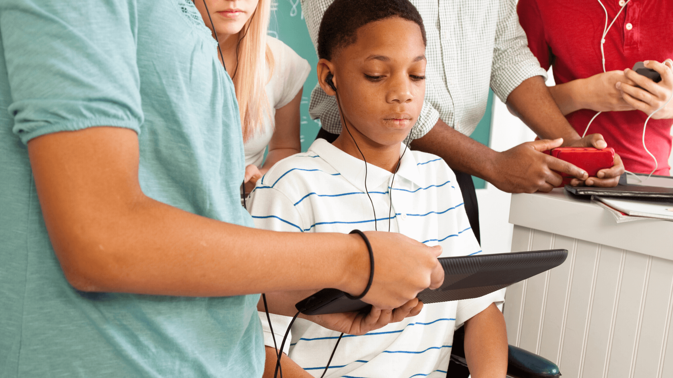 Teachers and classmates gathered around a tablet listening to audio accommodations.