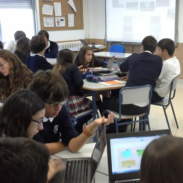 Students at the SEK International School Atlantico working collaboratively in small, breakout groups with student devices.