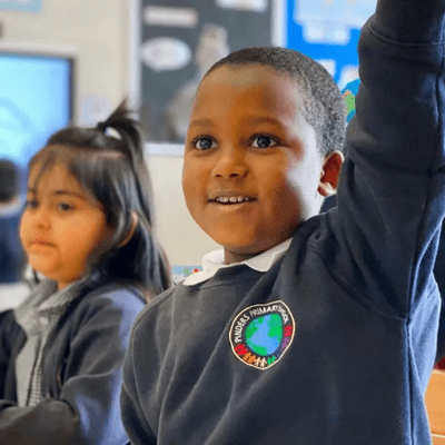 Young student raising hand in a classroom