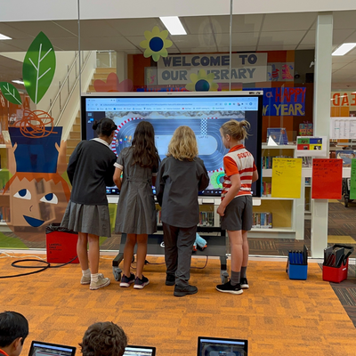 Four students collaborating at interactive display