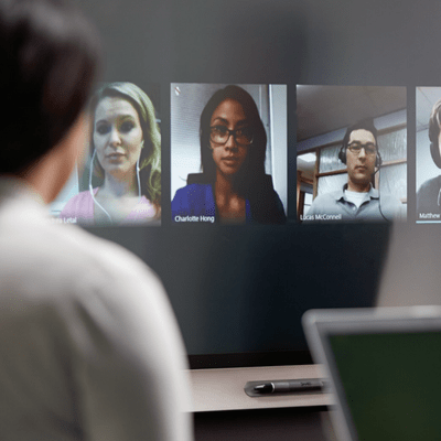 Employees connecting with coworkers through video chat using a SMART Board for Business.