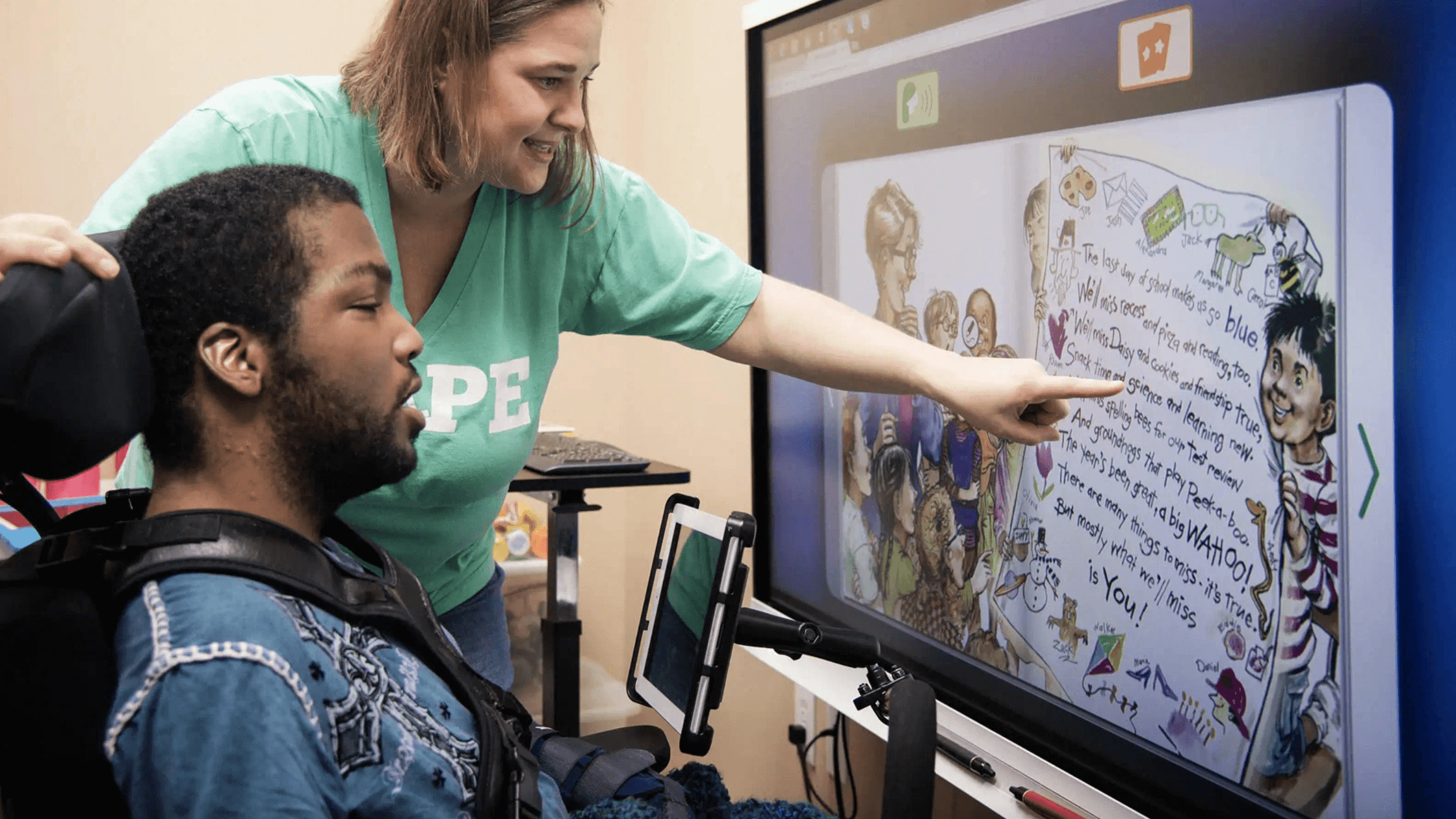 An educator assisting a special-needs student with interactive technology. 