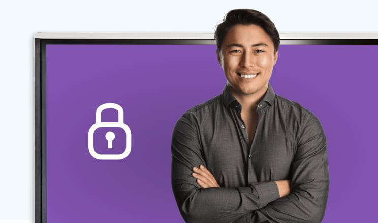 Man in a gray shirt smiling confidently with crossed arms, standing in front of a SMART interactive display showing a lock icon, symbolizing security.