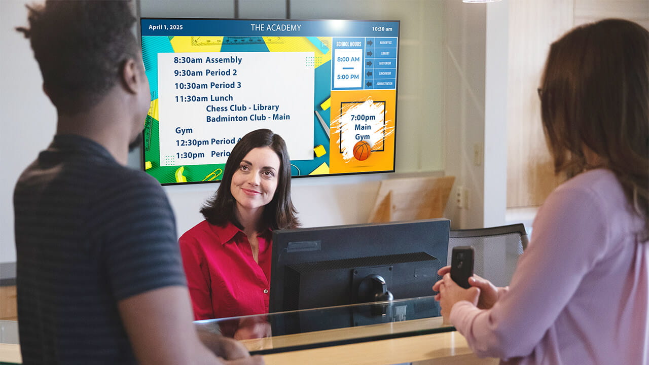Digital signage displaying schedules and school information in a reception area.